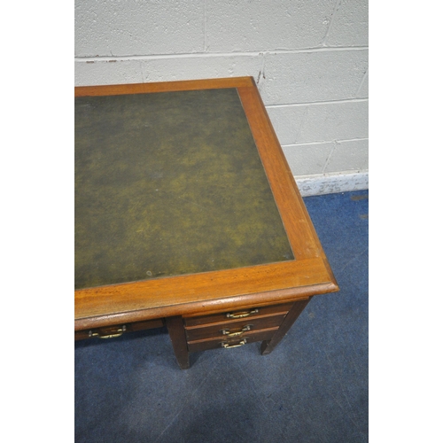 1317 - A 20TH CENTURY OAK KNEE HOLE DESK, with green leatherette writing surface, two brushing slides, eigh... 