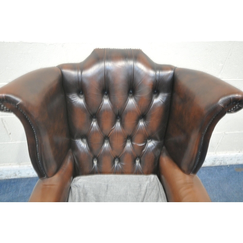 1319 - A BROWN LEATHER CHESTERFIELD WINGBACK ARMCHAIR, with buttoned back, later grey upholstered seat pads... 