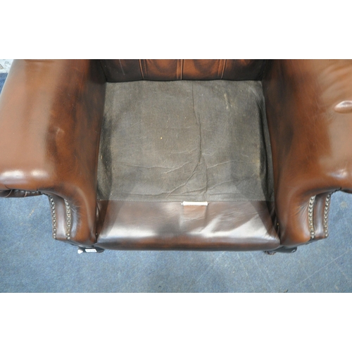 1319 - A BROWN LEATHER CHESTERFIELD WINGBACK ARMCHAIR, with buttoned back, later grey upholstered seat pads... 