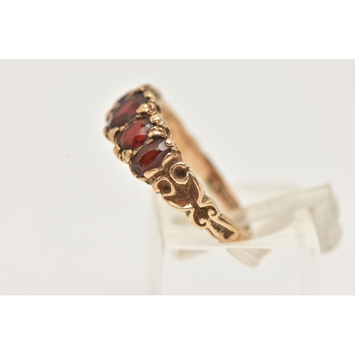 10 - A 9CT GOLD FIVE STONE GARNET RING, designed as a graduated line of five oval cut garnets with scroll... 