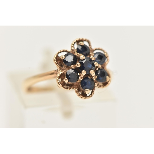 20 - A 9CT GOLD SAPPHIRE CLUSTER RING, designed as a cluster of circular cur sapphires within a shaped ro... 