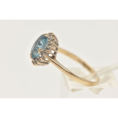 9 - A 9CT GOLD TOPAZ AND DIAMOND RING, designed as an oval blue topaz within a single cut diamond surrou... 