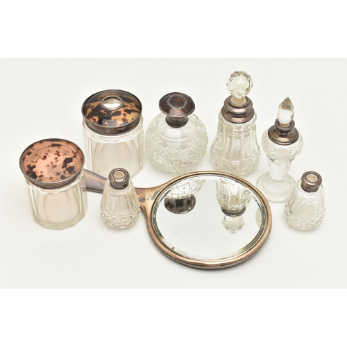 115 - AN ASSORTMENT OF SILVER LIDDED VANITY JARS AN A MIRROR, to include a cut glass scent bottle with a s... 