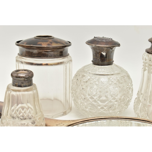 115 - AN ASSORTMENT OF SILVER LIDDED VANITY JARS AN A MIRROR, to include a cut glass scent bottle with a s... 