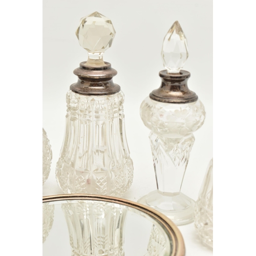 115 - AN ASSORTMENT OF SILVER LIDDED VANITY JARS AN A MIRROR, to include a cut glass scent bottle with a s... 