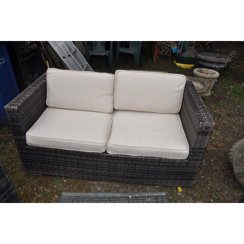 1012 - A RATTAN EFFECT GARDEN SUITE consisting of a 144cm wide sofa, two arm chairs and a square centre tab... 