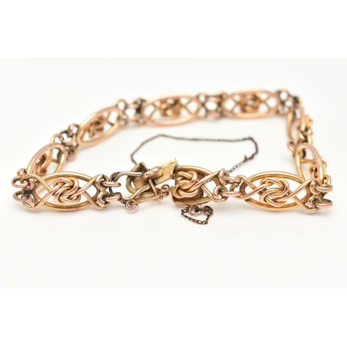 35 - A YELLOW METAL FANCY LINK BRACELET, open work design with twisted knot detail, fitted with a push pi... 