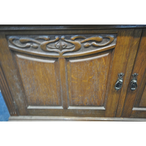 1214 - AN ART NUVEAU OAK SIDEBOARD, fitted with two drawers, above three cupboard doors, width 183cm x dept... 