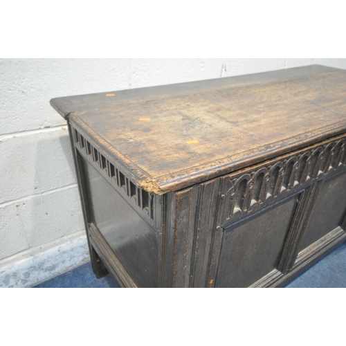 1230 - A GEORGIAN AND LATER OAK COFFER, the hinged lid enclosing a candle box, geometric carving to front a... 