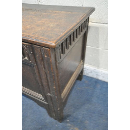 1230 - A GEORGIAN AND LATER OAK COFFER, the hinged lid enclosing a candle box, geometric carving to front a... 