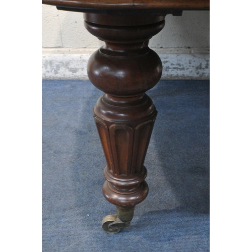 1233 - A LARGE VICTORIAN MAHOGANY WIND OUT DINING TABLE, with two additional leaves, raised on turned and t... 