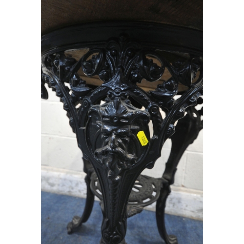 1248 - MITCHELLS AND BUTLER OF BIRMINGHAM, A BLACK PAINTED CAST IRON PUB TABLE, with foliate and mask detai... 