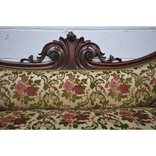 1258 - A VICTORIAN MAHOGANY SOFA, with scrolled armrests, wavy back and foliate carved centre, on octagonal... 