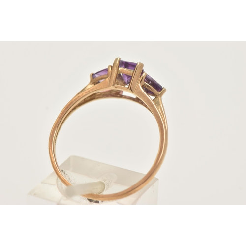 11 - A 9CT GOLD AMETHYST RING, set with a central rectangular cut amethyst in a four claw setting, flanke... 