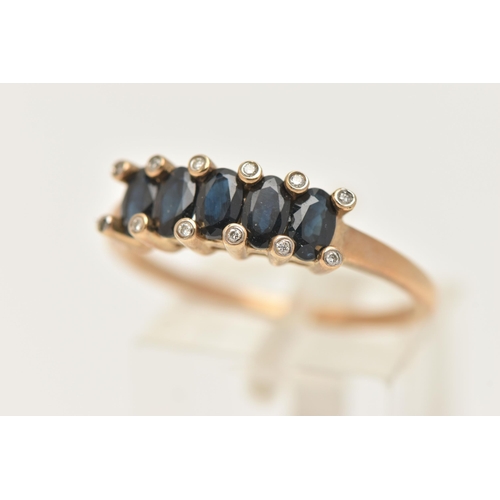 12 - A 9CT GOLD SAPPHIRE AND DIAMOND RING, designed as a row of five oval cut deep blue sapphires, shared... 