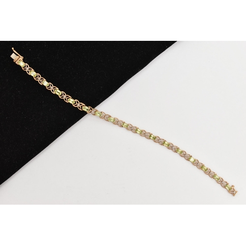 20 - A 9CT GOLD PERIDOT LINE BRACELET, designed as a series of seventeen oval cut peridots, each in a fou... 