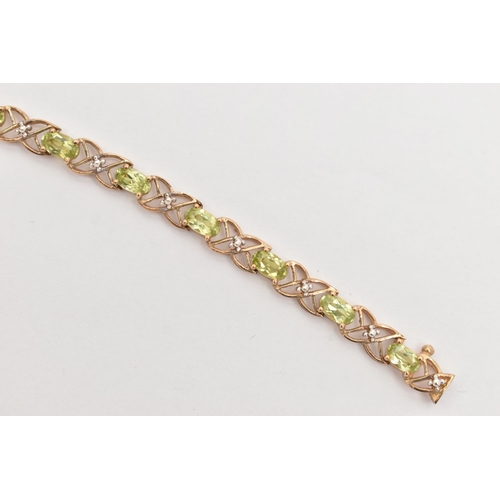 20 - A 9CT GOLD PERIDOT LINE BRACELET, designed as a series of seventeen oval cut peridots, each in a fou... 