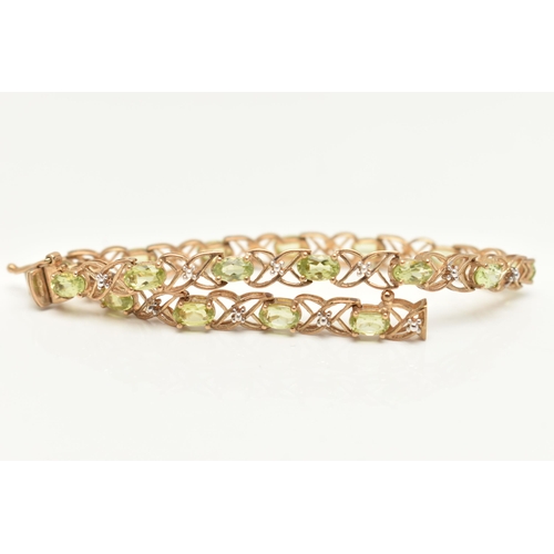 20 - A 9CT GOLD PERIDOT LINE BRACELET, designed as a series of seventeen oval cut peridots, each in a fou... 