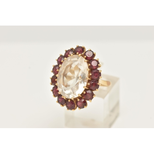 34 - A YELLOW METAL ROCK CRYSTAL AND GARNET CLUSTER RING, set with an oval shape rock crystal, measuring ... 