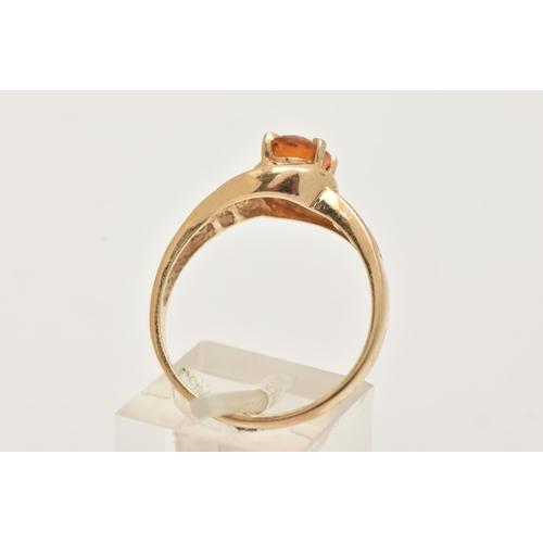 6 - A 9CT GOLD CITRINE RING, set with a central oval cut Citrine, in a four claw setting, cross over sho... 