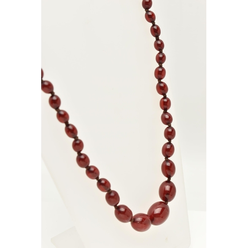 83 - A BAKELITE CHERRY AMBER COLOUR NECKLACE, graduated oval beads forty-nine beads in total, largest mea... 