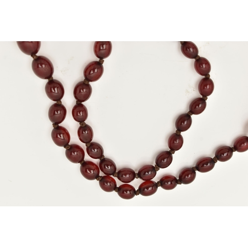 83 - A BAKELITE CHERRY AMBER COLOUR NECKLACE, graduated oval beads forty-nine beads in total, largest mea... 