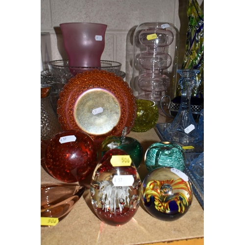 506 - A COLLECTION OF COLOURED GLASSWARE, comprising a collection of glass paperweights, an apple paperwei... 