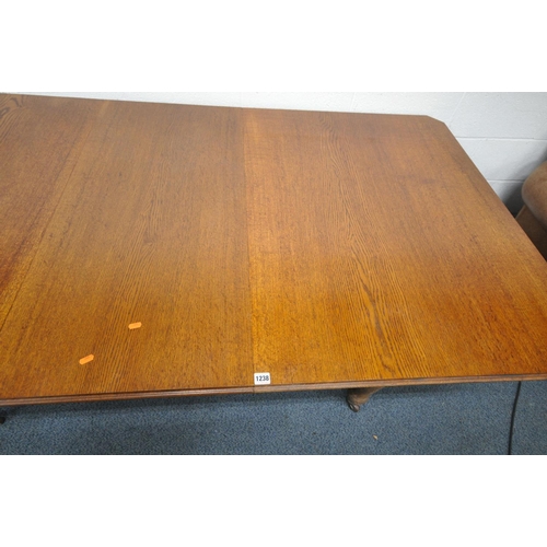 1192 - A 20TH CENTURY OAK EXTENDING DINING TABLE, with canted corners, raised on four turned legs and ceram... 