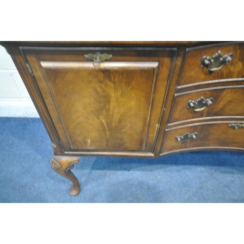 1197 - A 20TH CENTURY QUEEN ANNE STYLE CONCAVE WALNUT SIDEBOARD, fitted two cupboard doors, flanking three ... 