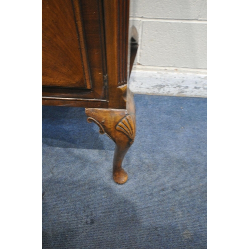 1197 - A 20TH CENTURY QUEEN ANNE STYLE CONCAVE WALNUT SIDEBOARD, fitted two cupboard doors, flanking three ... 