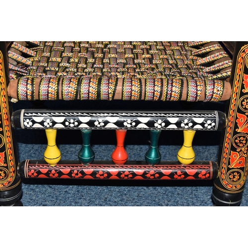 1242 - A PAIR OF 20TH CENTURY PAKISTANI CHARPAI CHAIRS, brightly painted decoration and woven fabric seats,... 