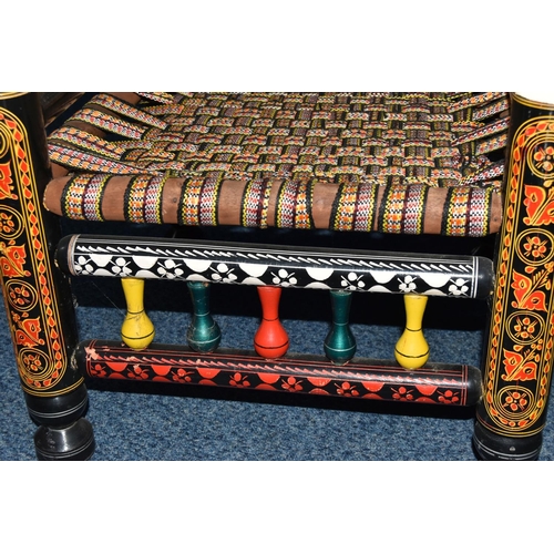 1242 - A PAIR OF 20TH CENTURY PAKISTANI CHARPAI CHAIRS, brightly painted decoration and woven fabric seats,... 