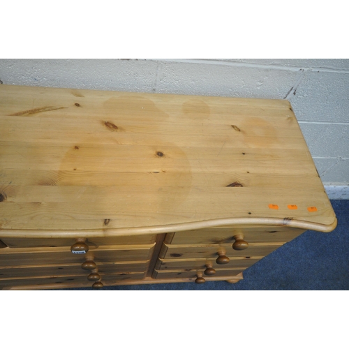 1205 - A MODERN PINE SERPENTINE SIDEBOARD, fitted with nine assorted drawers, on bun feet, width 128cm x de... 