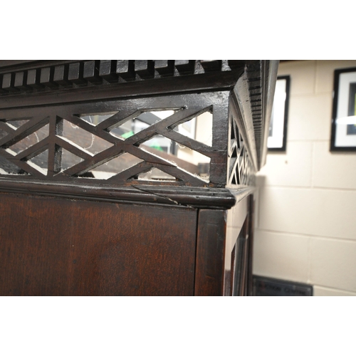 1218 - A CHIPPENDALE STYLE BOOKCASE ON STAND, with a pierced broken arch pediment, the double glazed doors ... 