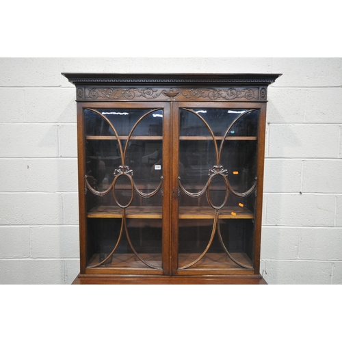 1297 - AN EARLY 20TH CENTURY MAHOGANY BOOKCASE ON STAND, the top with an overhanging cornice, the double as... 