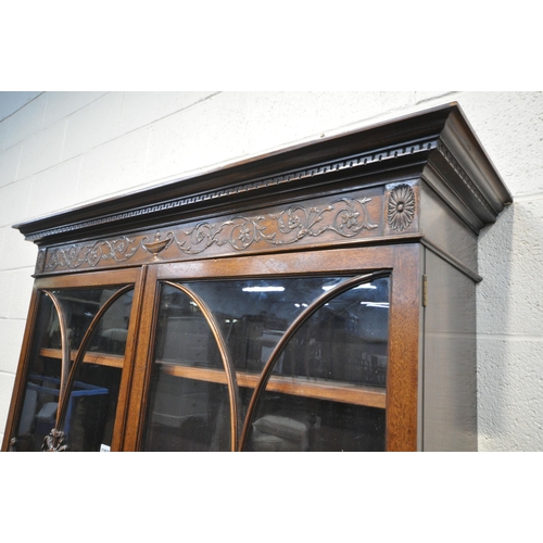 1297 - AN EARLY 20TH CENTURY MAHOGANY BOOKCASE ON STAND, the top with an overhanging cornice, the double as... 