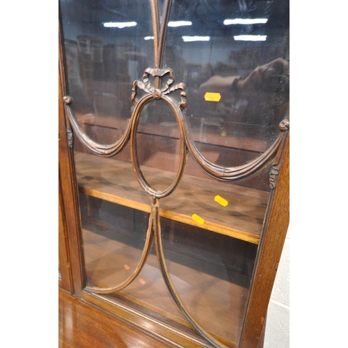 1297 - AN EARLY 20TH CENTURY MAHOGANY BOOKCASE ON STAND, the top with an overhanging cornice, the double as... 