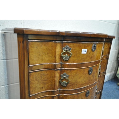 1302 - A REPRODUCTION WALNUT CHEST OF FOUR LONG GRADUATED DRAWERS, with a central shaped front, on bracket ... 