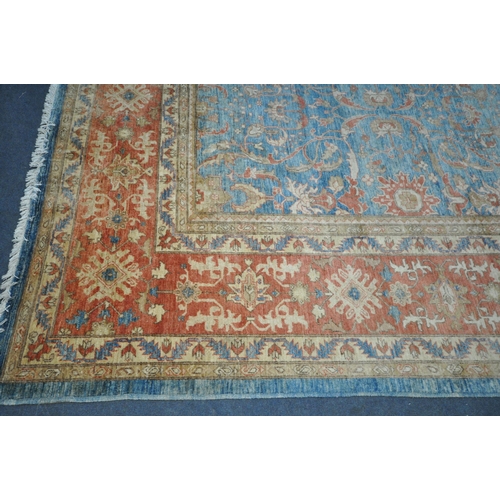 1321 - A LARGE MID TO LATE 20TH CENTURY WOOLLEN RUG, the repeating foliate pattern, within blue and orange ... 