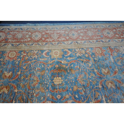 1321 - A LARGE MID TO LATE 20TH CENTURY WOOLLEN RUG, the repeating foliate pattern, within blue and orange ... 