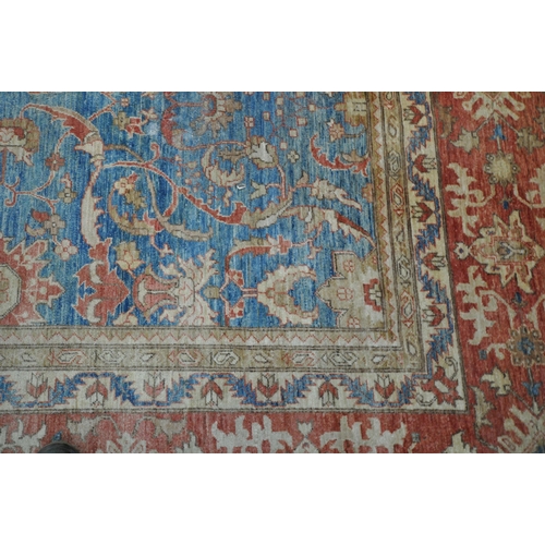 1321 - A LARGE MID TO LATE 20TH CENTURY WOOLLEN RUG, the repeating foliate pattern, within blue and orange ... 