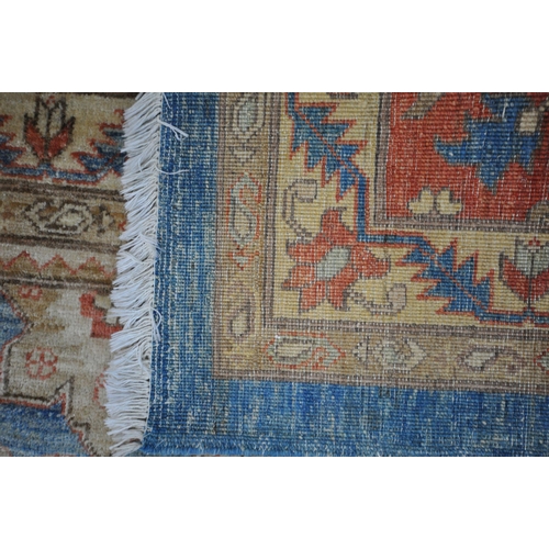 1321 - A LARGE MID TO LATE 20TH CENTURY WOOLLEN RUG, the repeating foliate pattern, within blue and orange ... 