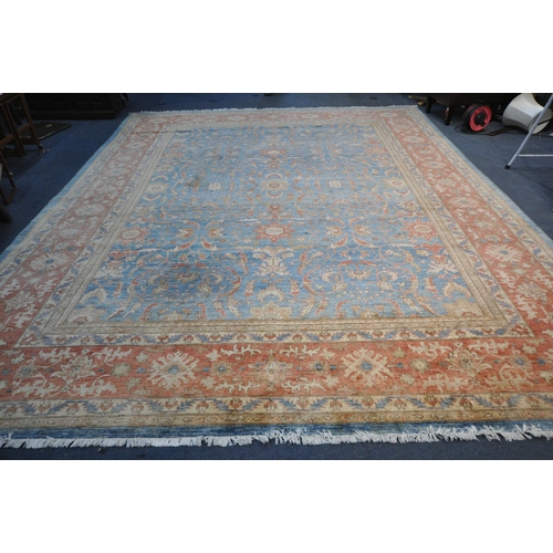 1321 - A LARGE MID TO LATE 20TH CENTURY WOOLLEN RUG, the repeating foliate pattern, within blue and orange ... 