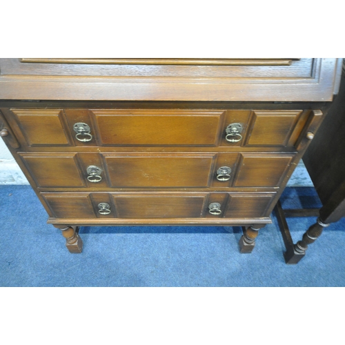 1233 - A LATE 20TH CENTURY OAK BUREAU, the linenfold fall front door enclosing a fitted interior, above thr... 