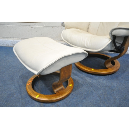 1277 - AN EKORNES STRESSLESS CREAM LEATHER SWIVEL RECLINING CHAIR, with an adjustable side tray, and footst... 