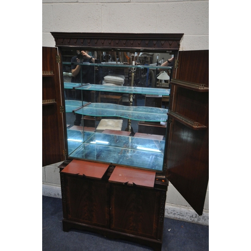 1280 - A MAHOGANY FOUR DOOR DRINKS CABINET, enclosing three glass shelves, cutting slide, atop a base with ... 