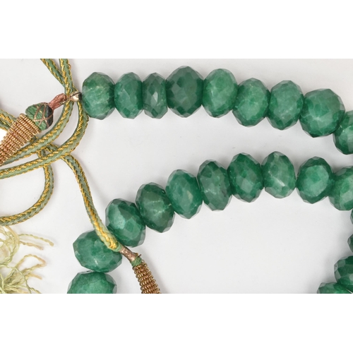 41 - A SINGLE STRAND OF HEAVILY TREATED, FACETED GREEN HARDSTONE BEADS, oval to round in shape, not unifo... 