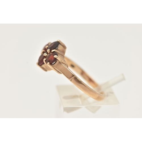 44 - A 9CT GOLD GARNET RING, set with four circular cut garnets, each in a four claw setting, to a polish... 