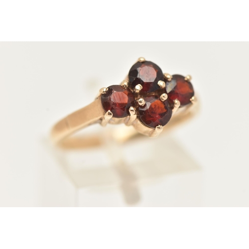 44 - A 9CT GOLD GARNET RING, set with four circular cut garnets, each in a four claw setting, to a polish... 