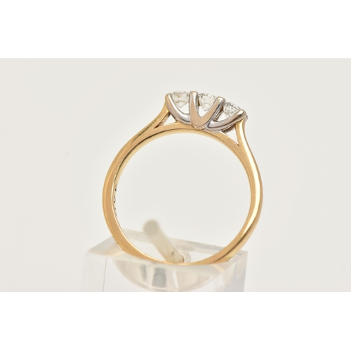 60 - A YELLOW METAL DIAMOND THREE STONE RING, set with three round brilliant cut diamonds, shared four cl... 